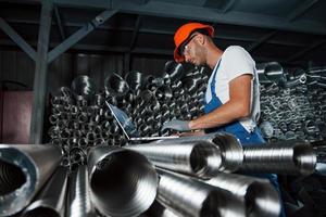 digitando su tastiera del computer. uomo nel uniforme lavori su il produzione. industriale moderno tecnologia foto