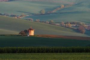 maestoso paesaggio di campo nel il sera. mulino a vento nel il centro di prato foto