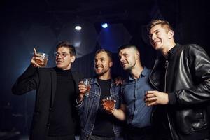 concezione di vita notturna. persone avere divertimento nel il club. con alcool nel mani foto