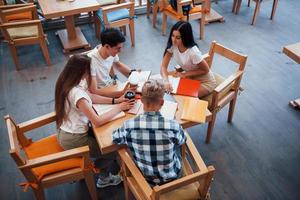 aereo Visualizza. quattro giovane studenti nel casuale Abiti avere incontro a piovoso giorno foto