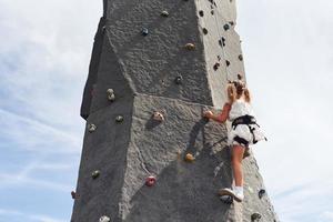 poco ragazza nel casuale bianca Abiti formazione roccia arrampicata all'aperto foto