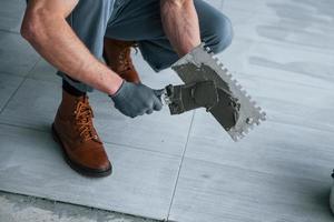 uomo nel grigio uniforme lavori con piatto in casa nel moderno grande ufficio a giorno foto