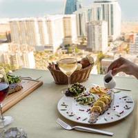 donna versando la salsa a un pasto di pesce con il limone foto