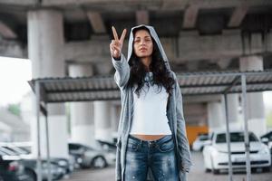 uno ma forte. ritratto di bellissimo giovane donna in piedi sotto il ponte all'aperto foto