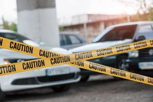 bellissima sole trave. giallo attenzione nastro vicino il auto parcheggio lotto a giorno. crimine scena foto