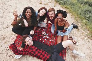 aereo Visualizza. gruppo di persone avere picnic su il spiaggia. amici avere divertimento a fine settimana tempo foto