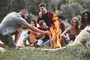 alto fuoco. gruppo di persone avere picnic su il spiaggia. amici avere divertimento a fine settimana tempo foto