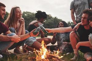 ubriaco e contento. gruppo di persone avere picnic su il spiaggia. amici avere divertimento a fine settimana tempo foto