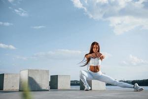 esercizi per gambe. tiro di allegro donna fare fitness vicino il lago a giorno foto