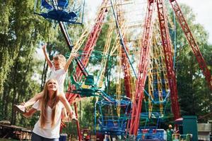 allegro poco ragazza sua madre avere un' bene tempo nel il parco insieme vicino attrazioni foto