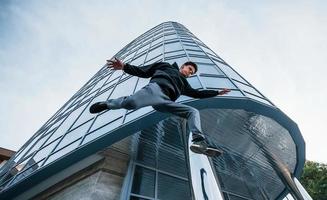 giovane uomo fare parkour nel il città a giorno. concezione di estremo gli sport foto