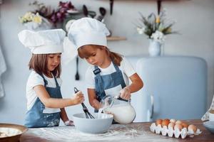 famiglia bambini nel bianca capocuoco uniforme preparazione cibo su il cucina foto