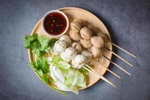 Polpette su piatto con con speziato salsa, grigliato polpetta e Maiale sfera, carne palla su spiedini e fresco coriandolo verdure cavolo, tailandese cibo asiatico cibo carne palle - Maiale palle foto