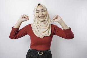 un' giovane asiatico musulmano donna con un' contento riuscito espressione indossare un' hijab isolato di bianca sfondo foto