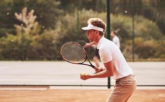 giovane tennis giocatore nel allegro Abiti è su il Tribunale all'aperto foto