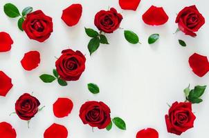 rosso Rose con suo petali e le foglie mettere su bianca sfondo con cuore forma spazio per San Valentino giorno. piatto posare sfondo concetto. foto