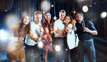 gruppo di allegro giovane persone avere festa e festeggiare nuovo anno in casa foto