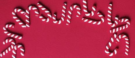 Natale composizione con telaio di caramella canne su rosso sfondo. copia spazio per testo. bandiera foto