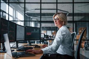 femmina agente di cambio nel formale Abiti lavori nel il ufficio con finanziario mercato foto