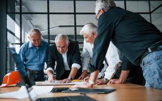 anziano squadra di anziano uomo d'affari architetti lavori con Piano nel il ufficio foto