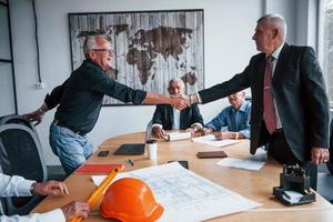 fare stretta di mano. anziano squadra di anziano uomo d'affari architetti avere un' incontro nel il ufficio foto