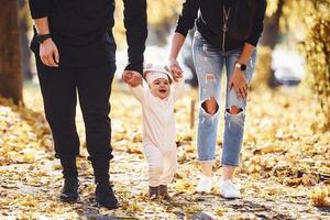 vicino su Visualizza. allegro famiglia avendo divertimento insieme con loro bambino nel bellissimo autunno parco foto