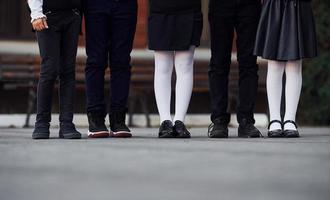 vicino su Visualizza di bambini nel scuola uniforme quello è all'aperto insieme vicino formazione scolastica edificio foto