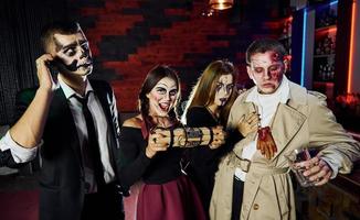 amici con bomba nel mani è su il tematico Halloween festa nel pauroso trucco e costumi foto