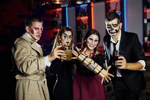 amici con bomba nel mani è su il tematico Halloween festa nel pauroso trucco e costumi foto