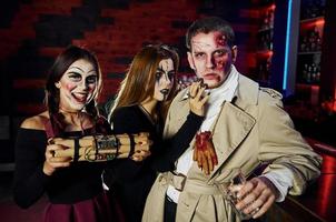 amici con bomba nel mani è su il tematico Halloween festa nel pauroso trucco e costumi foto