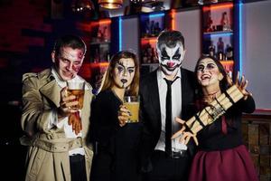 amici con bomba nel mani è su il tematico Halloween festa nel pauroso trucco e costumi foto