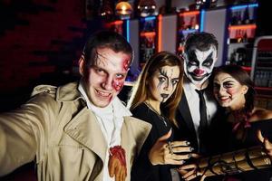 amici con bomba nel mani è su il tematico Halloween festa nel pauroso trucco e costumi foto