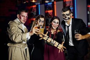 amici con bomba nel mani è su il tematico Halloween festa nel pauroso trucco e costumi foto