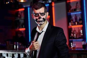 ritratto di uomo quello è su il tematico Halloween festa nel pauroso scheletro trucco e costume foto