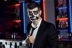 ritratto di uomo quello è su il tematico Halloween festa nel pauroso scheletro trucco e costume foto