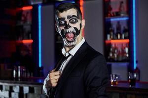 ritratto di uomo quello è su il tematico Halloween festa nel pauroso scheletro trucco e costume foto