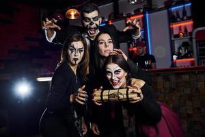 mostrando bomba. amici è su il tematico Halloween festa nel pauroso trucco e costumi foto