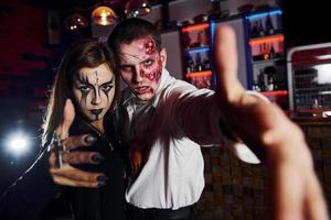 in posa per il telecamera. amici è su il tematico Halloween festa nel pauroso trucco e costumi foto