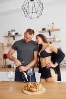 donna nel sexy nero biancheria intima con sua marito su il cucina foto