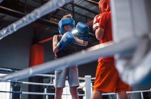 Due ragazzi nel protettivo attrezzatura avere sparring e combattente su il boxe squillare foto