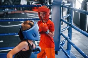 Due ragazzi nel protettivo attrezzatura avere sparring e combattente su il boxe squillare foto