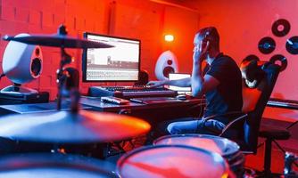 giovane cantato ingegnere Lavorando e miscelazione musica in casa nel il studio foto