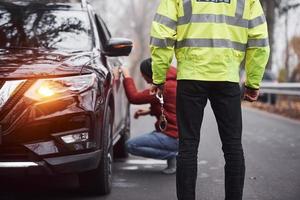 polizia ufficiale nel verde uniforme catturato automobile furto su il strada foto