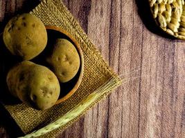 mucchio di crudo patate su buio di legno sfondo. preparazione di Patata la minestra o piatto, Perfetto per pubblicità opuscolo sfondo foto