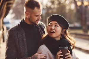 contento multirazziale coppia insieme all'aperto nel il città. asiatico ragazza con sua caucasico fidanzato foto
