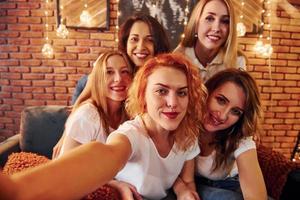 allegro donne assunzione autoscatto e festeggiare nuovo anno vacanze in casa di Natale decorato camera foto