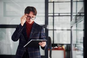 ufficio lavoratore nel bicchieri e nel formale Abiti in piedi in casa foto