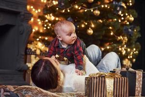 madre con sua poco figlio festeggiare nuovo anno e Natale vacanze in casa foto