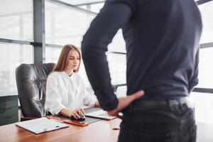 posteriore Visualizza. donna e uomo nel formale Abiti Lavorando insieme in casa nel il ufficio di tavolo foto