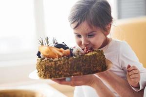 allegro poco ragazza mangiare fresco dietetico torta su il cucina foto